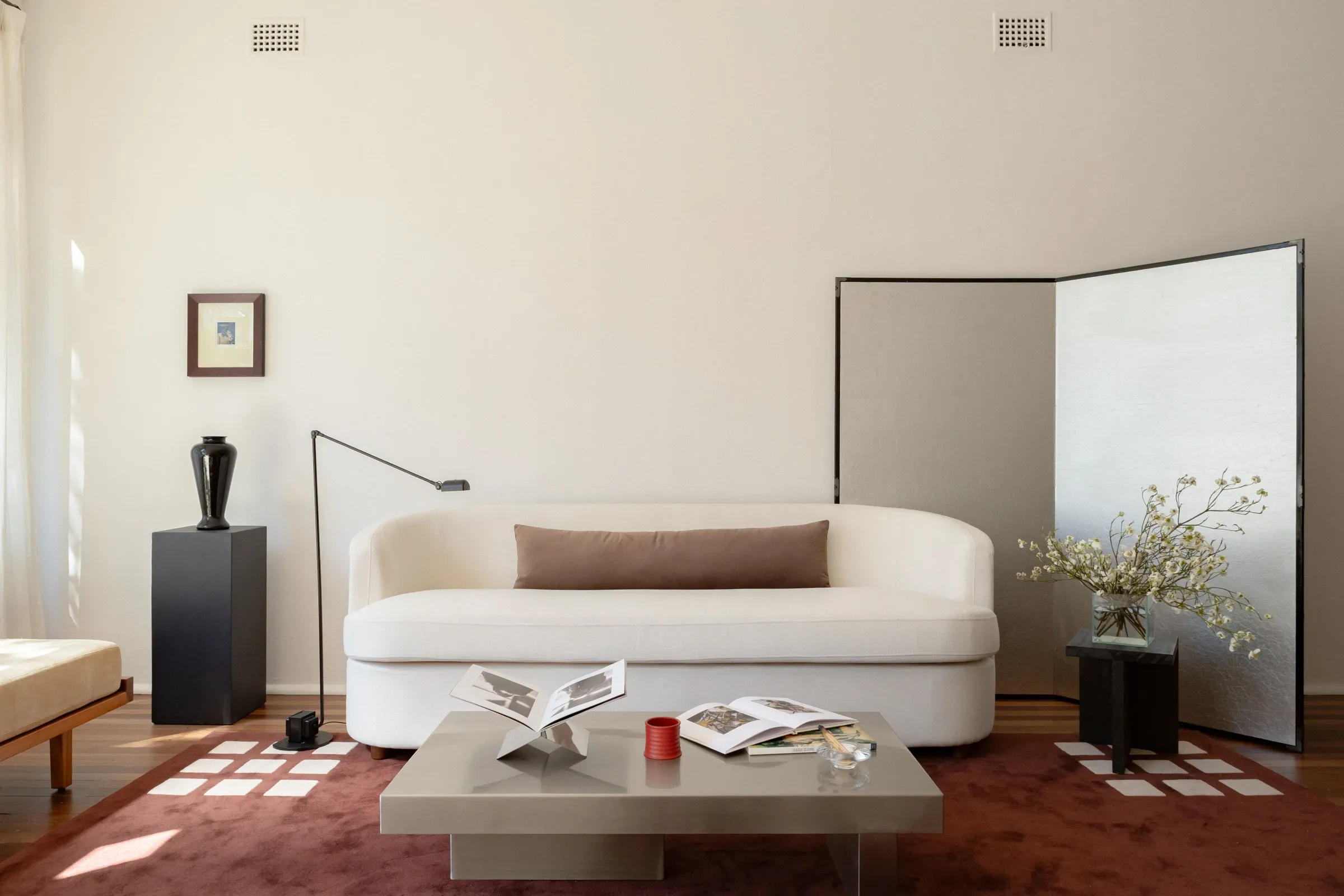 A sunlit living room at My Verona, with sculptural furniture and warm timber floors
